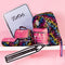 Colorful school supplies including a backpack, notebook, and pink pouch on a pink background.